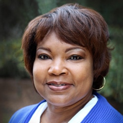 Female in blue shirt smiling at the camera